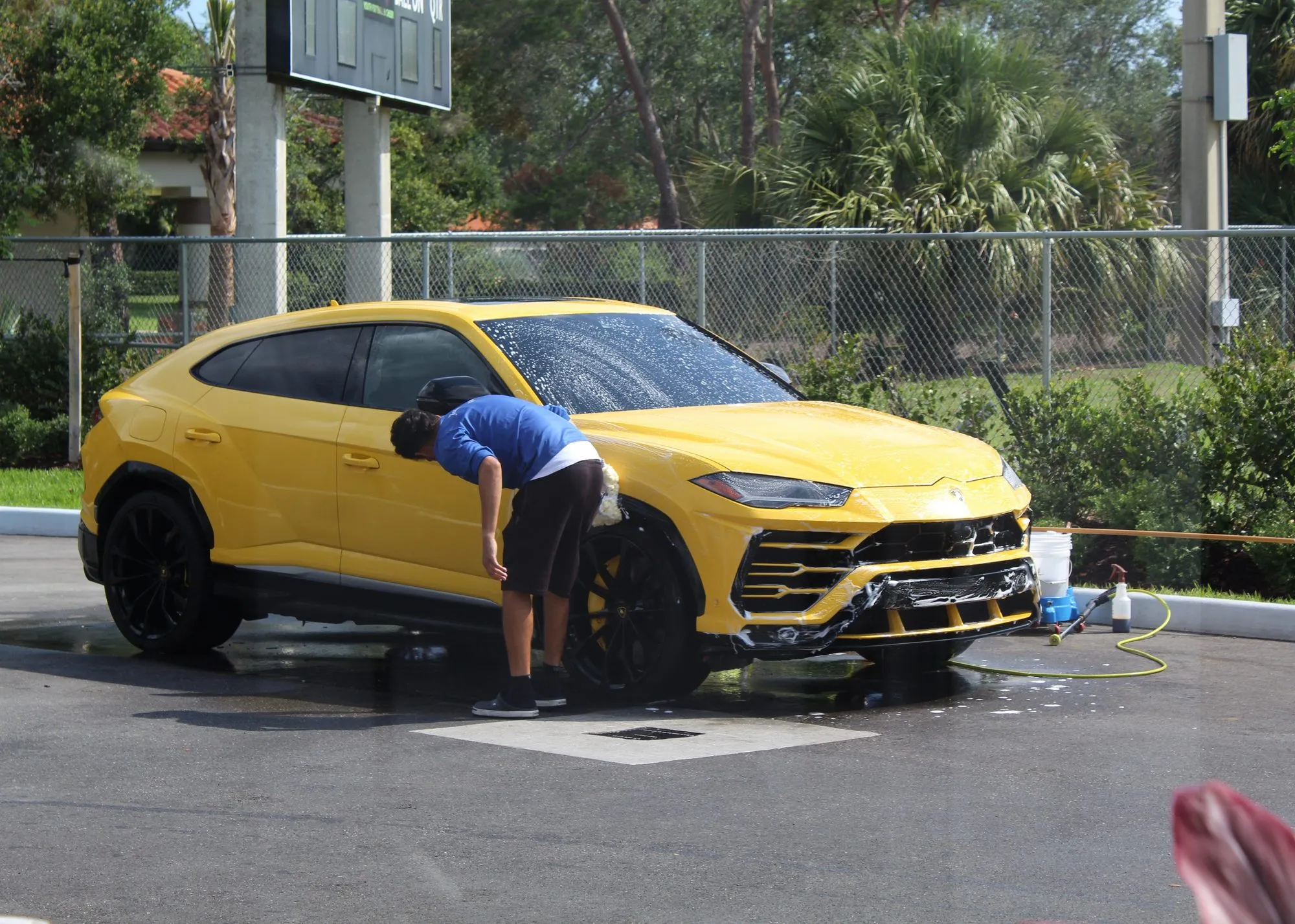 A yellow Lamborghini Urus being hand-washed