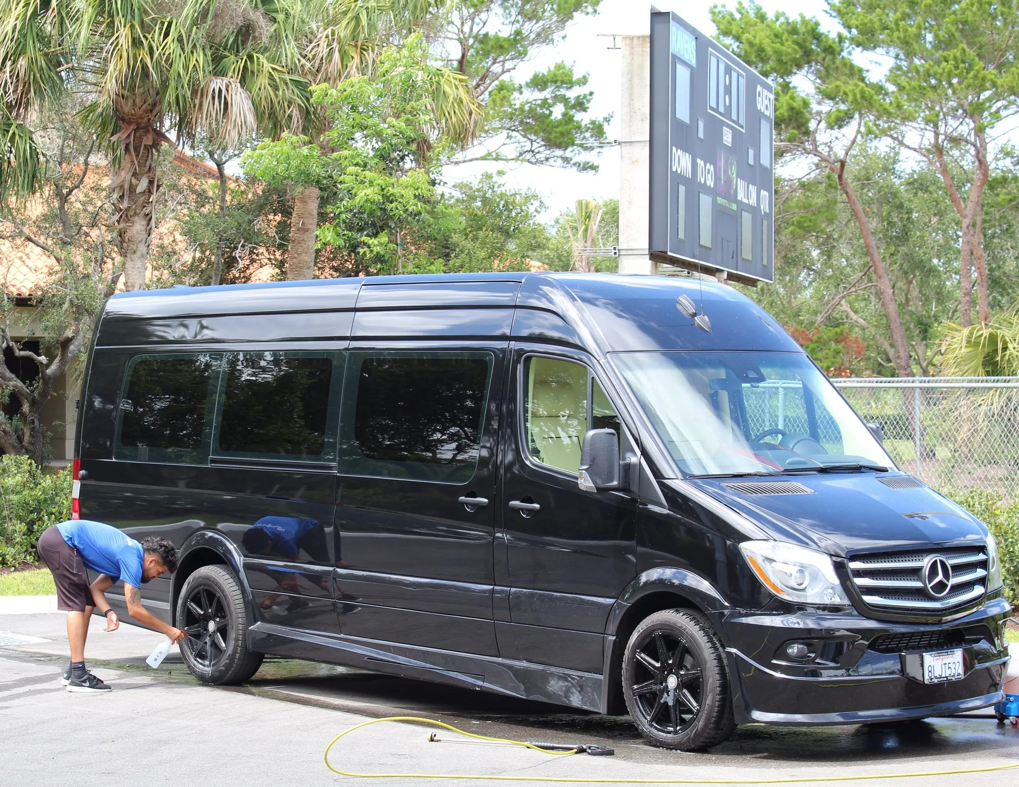 A black Mercedes-Benz Sprinter van after a wash